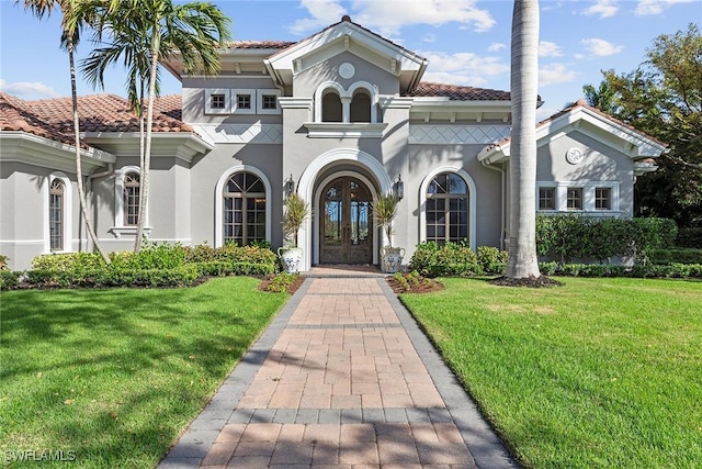 view of front of property with a tile roof, a front yard, and french doors