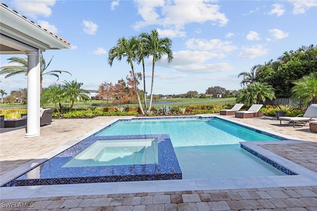 view of pool featuring a patio area, a fenced backyard, and a pool with connected hot tub