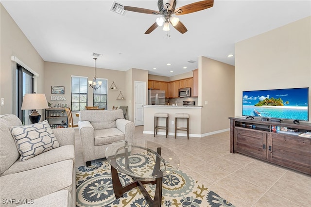 living room with ceiling fan with notable chandelier and light tile patterned floors