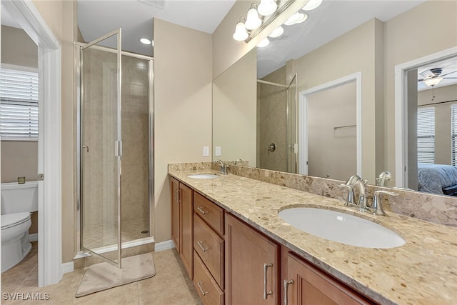 bathroom featuring toilet, ceiling fan, walk in shower, vanity, and tile patterned flooring