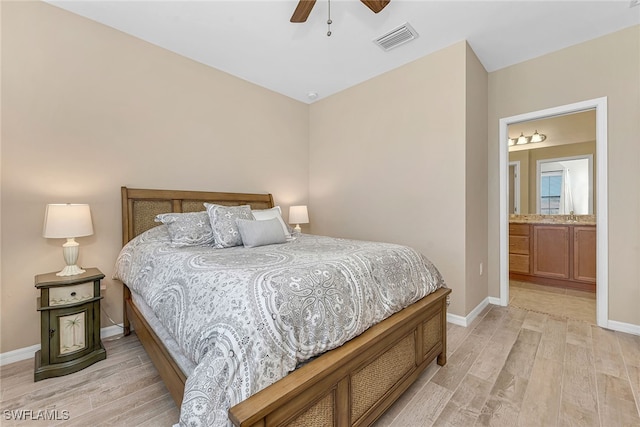 bedroom featuring connected bathroom, ceiling fan, sink, and light wood-type flooring