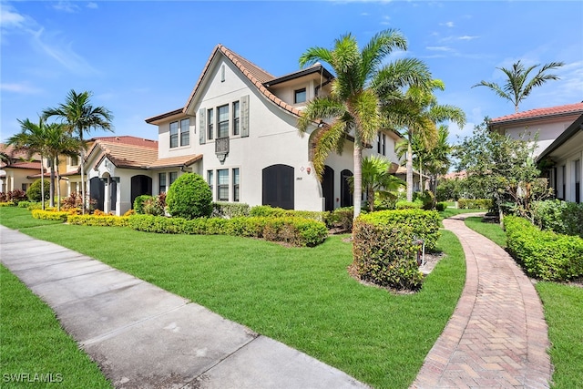 mediterranean / spanish home featuring a front lawn