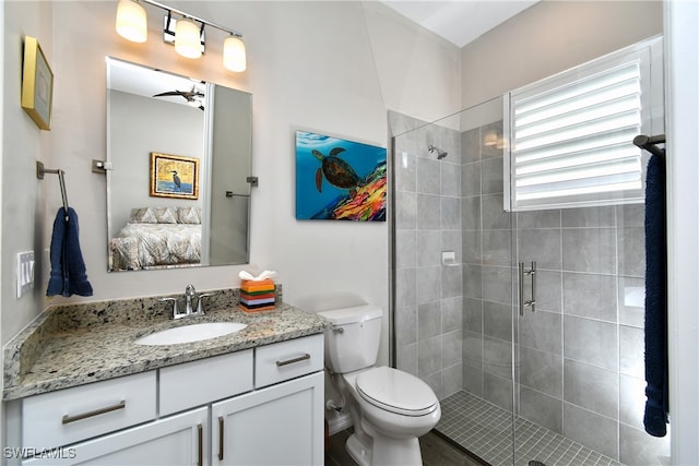 bathroom with vanity, a shower with door, ceiling fan, wood-type flooring, and toilet