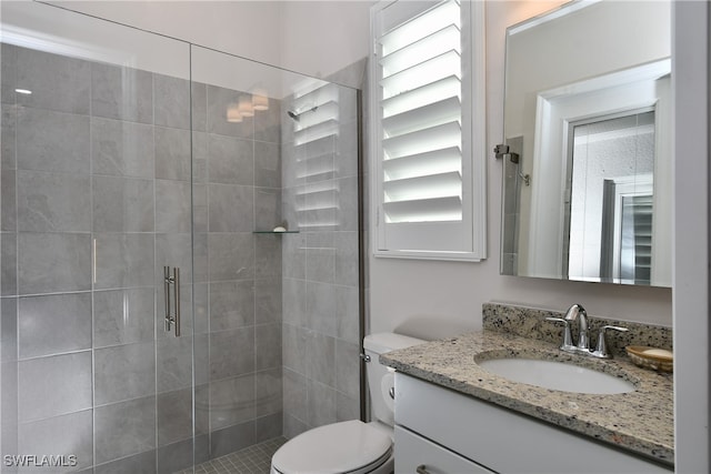 bathroom with walk in shower, vanity, and toilet