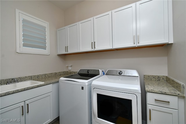 laundry room featuring cabinets, washer and dryer, and sink