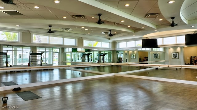 exercise room with a towering ceiling and ceiling fan