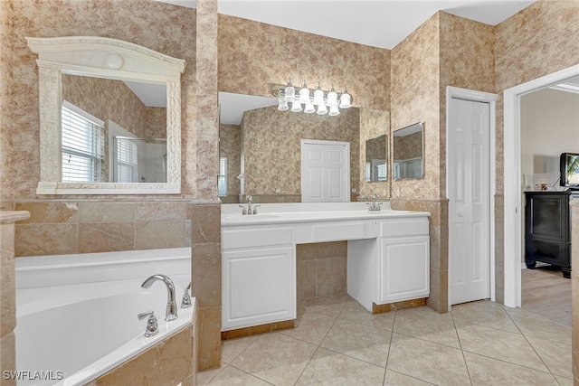 bathroom featuring vanity, tiled tub, and tile patterned flooring