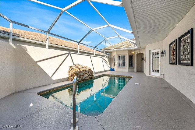 view of swimming pool featuring a patio and glass enclosure