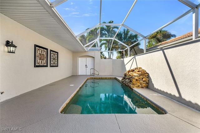 view of pool with a patio and glass enclosure