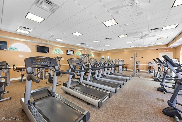 exercise room with a paneled ceiling and ceiling fan