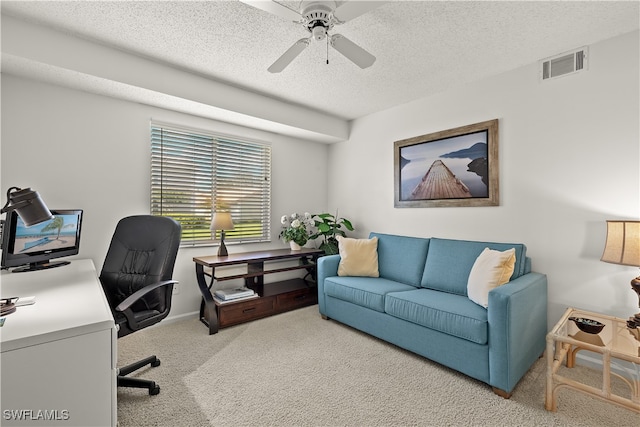 carpeted office with ceiling fan and a textured ceiling