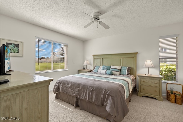 bedroom featuring ceiling fan, a textured ceiling, and multiple windows