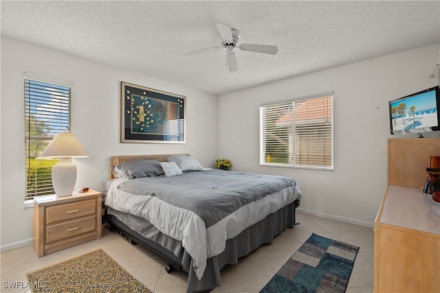 bedroom with a textured ceiling, ceiling fan, and light tile patterned flooring