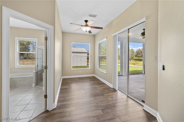 doorway with light hardwood / wood-style floors and ceiling fan