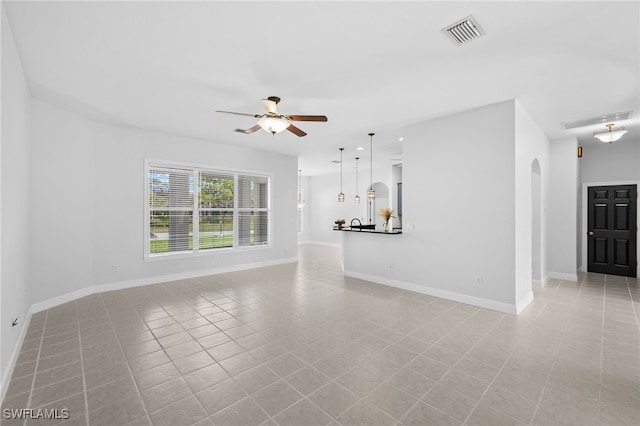 unfurnished living room with light tile patterned floors and ceiling fan