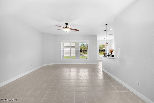 unfurnished living room featuring light tile patterned floors and ceiling fan