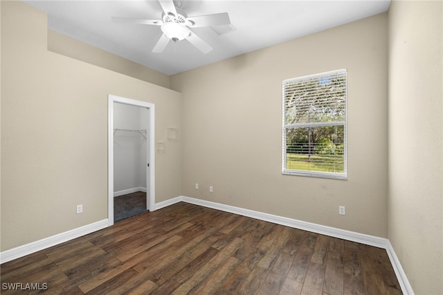 3645 70th Ave NE, Naples, FL 34120 - unfurnished bedroom featuring multiple windows, dark wood-type flooring, a spacious closet, and a closet