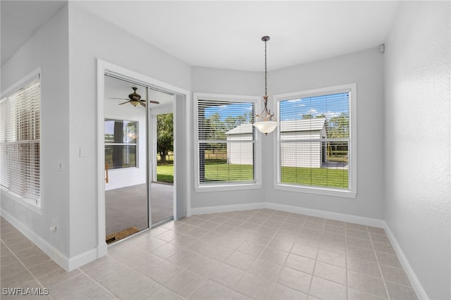 unfurnished dining area with ceiling fan and light tile patterned floors