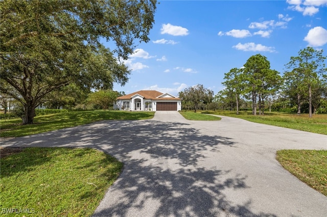 single story home featuring a garage and a front yard