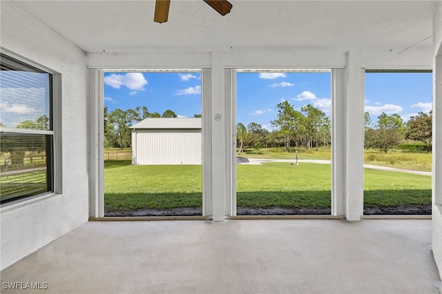 unfurnished sunroom with ceiling fan