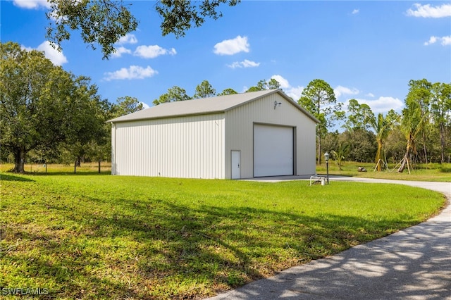 view of outdoor structure featuring a garage and a lawn