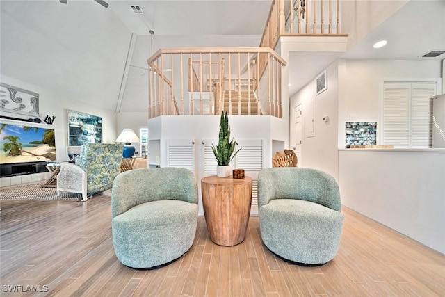 sitting room featuring a towering ceiling and hardwood / wood-style floors