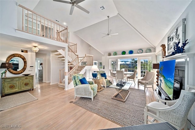 living room featuring ceiling fan, high vaulted ceiling, and light wood-type flooring