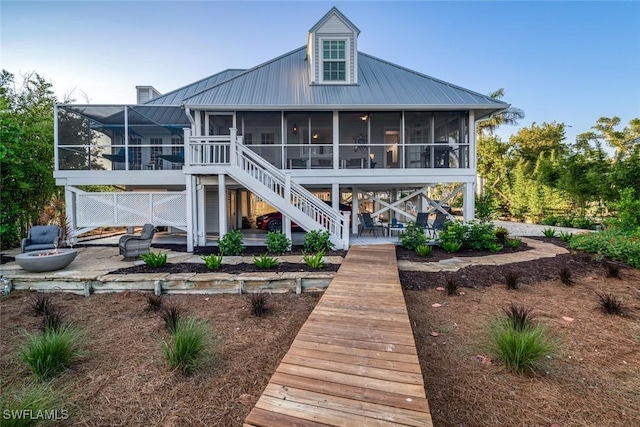 rear view of property with a sunroom and a patio area