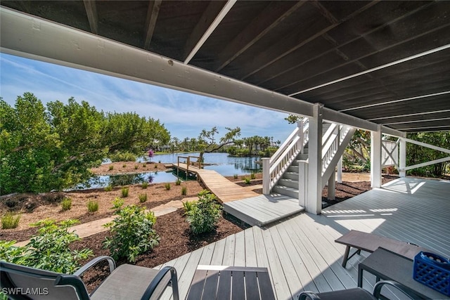 wooden terrace with a water view and a boat dock