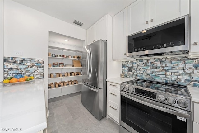 kitchen with white cabinetry, decorative backsplash, and appliances with stainless steel finishes