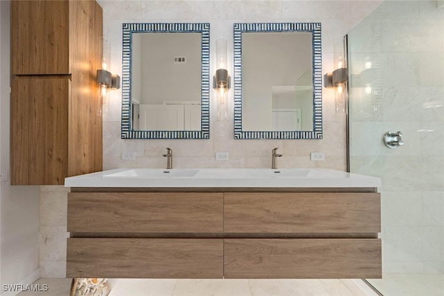 bathroom featuring walk in shower, vanity, and tile walls