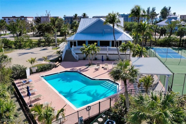 view of pool with tennis court and a patio