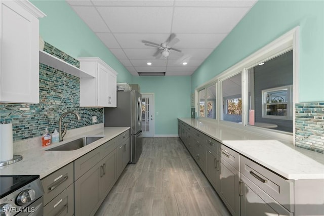 kitchen featuring gray cabinets, white cabinetry, sink, stainless steel appliances, and a drop ceiling