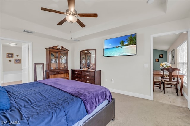 bedroom with connected bathroom, ceiling fan, and light colored carpet