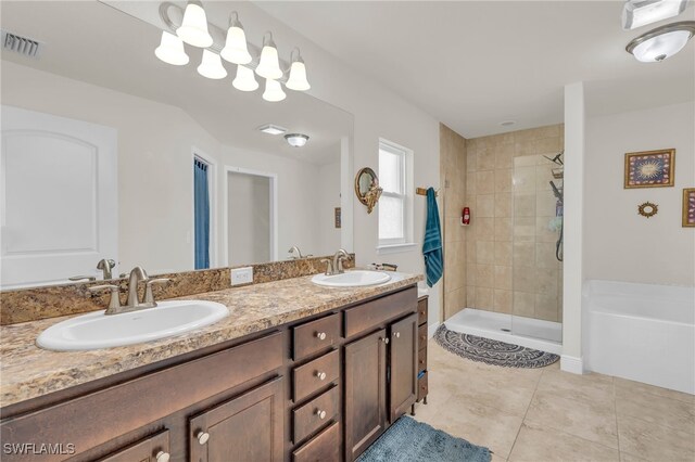 bathroom featuring vanity, tiled shower, and tile patterned flooring