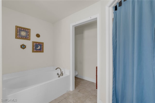 bathroom featuring toilet, a bathing tub, and tile patterned flooring