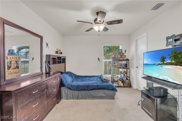 carpeted bedroom with ceiling fan and multiple windows