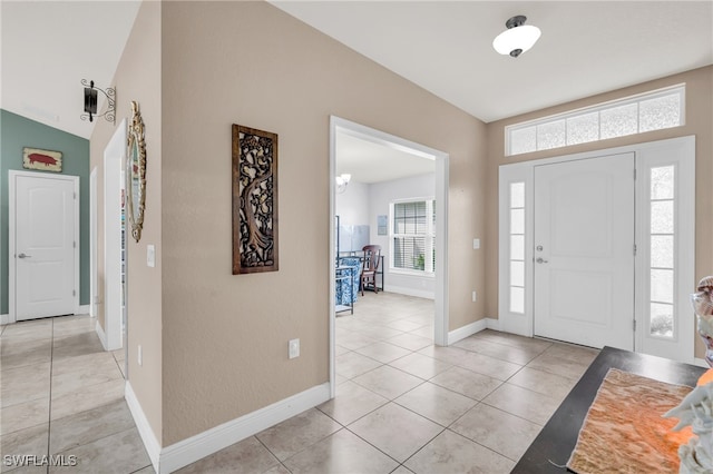 tiled entryway with lofted ceiling