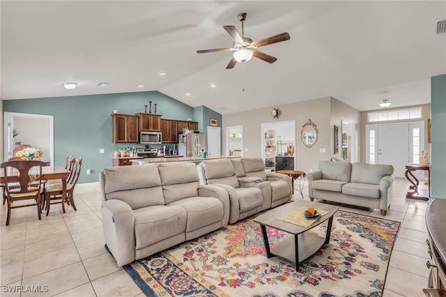 tiled living room featuring vaulted ceiling, ceiling fan, and plenty of natural light