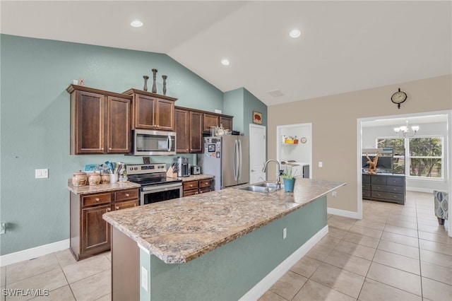 kitchen with sink, an island with sink, stainless steel appliances, lofted ceiling, and a chandelier