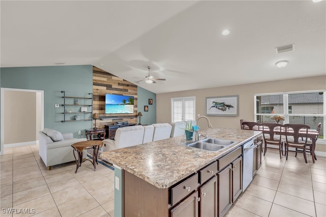 kitchen with dishwasher, sink, ceiling fan, vaulted ceiling, and a kitchen island with sink