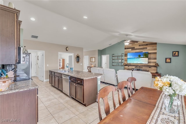 kitchen with an island with sink, ceiling fan, vaulted ceiling, stainless steel appliances, and sink