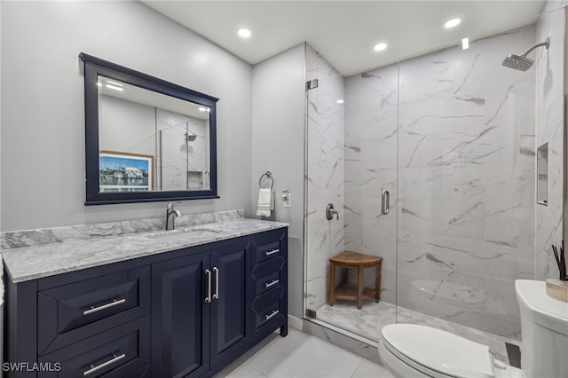 bathroom featuring vanity, a shower with shower door, and toilet