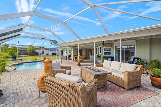 view of swimming pool with a patio, glass enclosure, and an outdoor living space with a fire pit