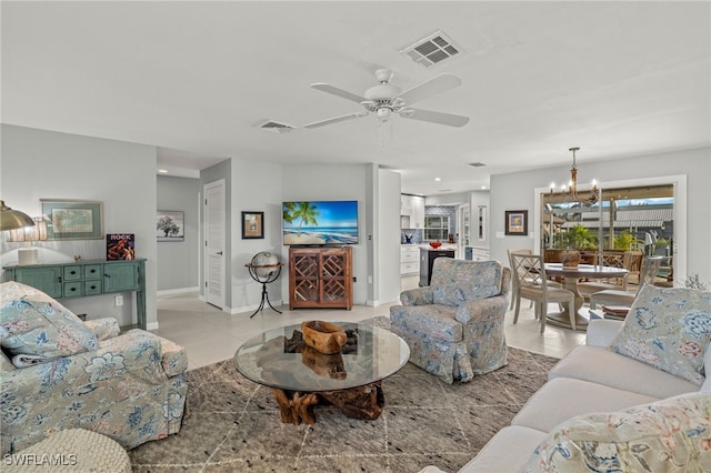 living room featuring light tile patterned floors and ceiling fan with notable chandelier