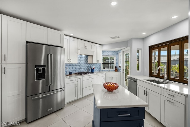 kitchen with white cabinets, backsplash, stainless steel appliances, and sink