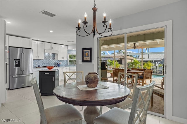 dining area with light tile patterned floors and an inviting chandelier