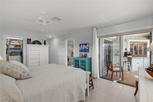 tiled bedroom featuring ceiling fan, a spacious closet, and a closet