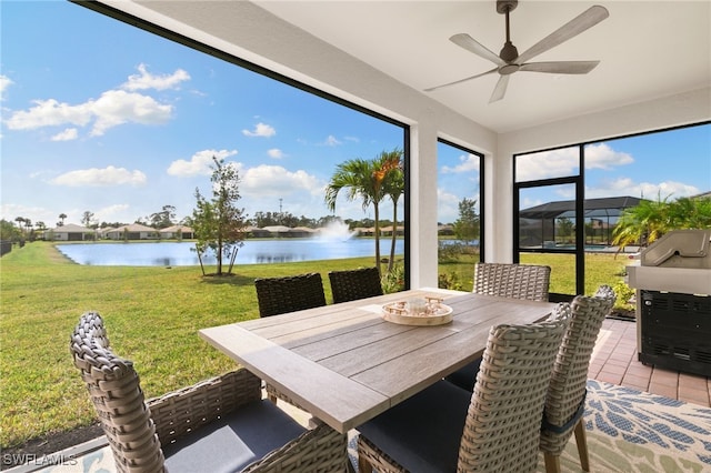 sunroom / solarium with a water view and ceiling fan