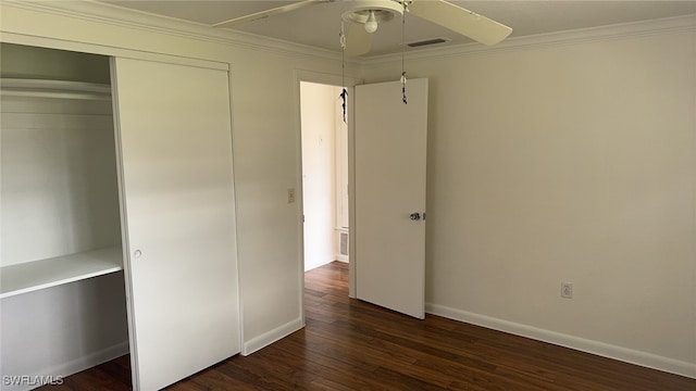 unfurnished bedroom featuring dark wood-type flooring, a closet, ornamental molding, and ceiling fan